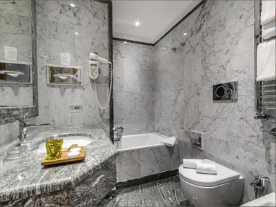 a bathroom with a tub and a toilet and a sink at Hotel Giolli Nazionale in Rome