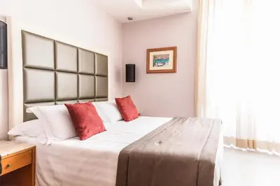 a bedroom with a large bed with red pillows at Hotel Giolli Nazionale in Rome