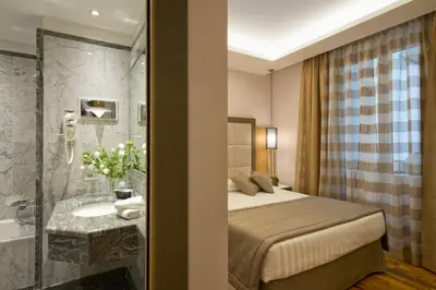 a hotel room with a bed and a bathroom at Hotel Giolli Nazionale in Rome