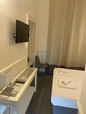 a small room with a bed and a tv on the wall at Arts & Rooms in Rome