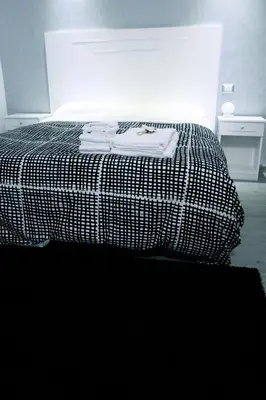 a bed with a black and white comforter in a room at Arts & Rooms in Rome