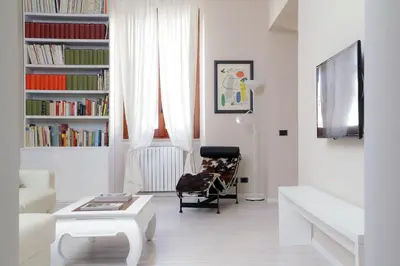 a living room with a chair and a book shelf at RomeAsYouLike-Colosseo Experience45 in Rome