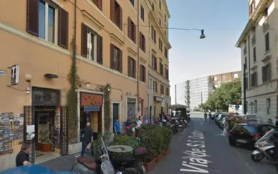 a street with a group of motorcycles parked next to buildings at RomeAsYouLike-Colosseo Experience45 in Rome