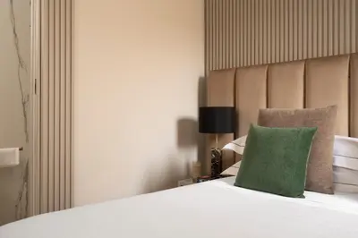 a bedroom with a white bed with green pillows at Palazzo Venere in Rome