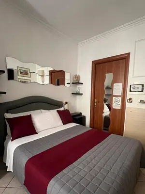 a bedroom with a large bed with red and white pillows at Città Eterna Guest House in Rome