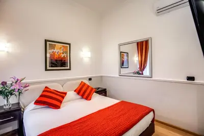 a bedroom with a bed with orange and orange pillows at Hotel Everest Inn Rome in Rome