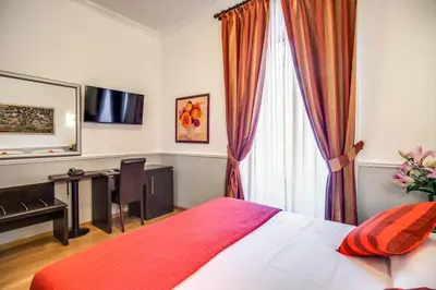 a bedroom with a bed and a desk and a window at Hotel Everest Inn Rome in Rome