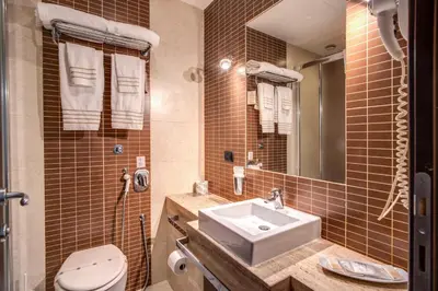 a bathroom with a sink and a toilet and a mirror at Hotel Everest Inn Rome in Rome