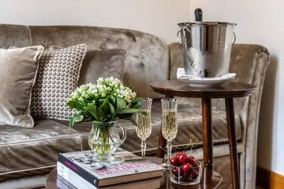 a coffee table with a couch and a vase of flowers at Relais Rione Ponte in Rome