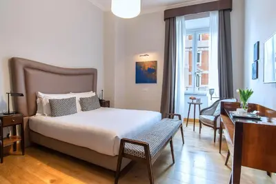 a bedroom with a bed and a desk and a chair at Relais Rione Ponte in Rome