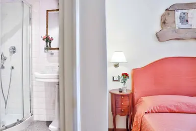 a bedroom with a bed and a bathroom with a sink at Casa De' Fiori in Rome