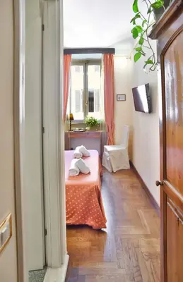 a room with a bed with a table and a window at Casa De' Fiori in Rome