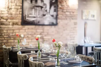 a table with red and white flowers in a restaurant at Casa De' Fiori in Rome