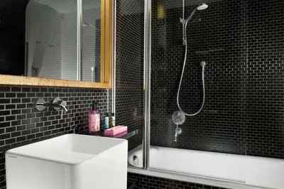 a black tiled bathroom with a shower and a sink at Hotel Pulitzer in Rome