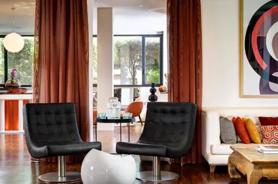 two black chairs in a living room with a couch at Hotel Pulitzer in Rome