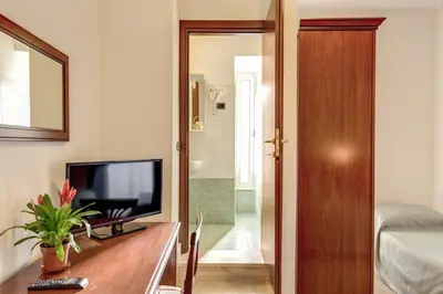 a living room with a television on a wooden table at Hotel Flavio in Rome