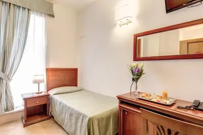 a hotel room with a bed and a mirror at Hotel Flavio in Rome