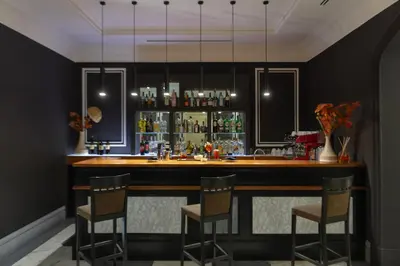 a bar in a room with three bar stools at Hotel Principe Torlonia in Rome