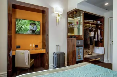 a bedroom with a bed and a desk and a mirror at Hotel Gioberti in Rome