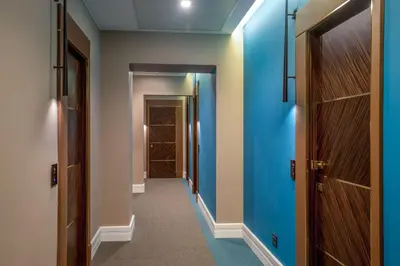 a hallway with blue walls and wooden doors at Hotel Gioberti in Rome