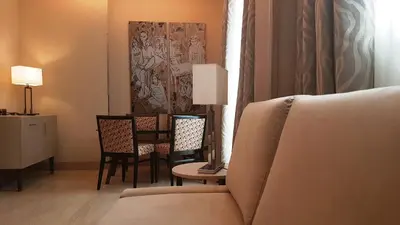 a living room with a couch and a table and chairs at Hotel Genova in Rome