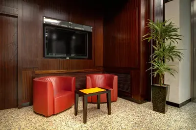 a waiting room with two red chairs and a tv at Hotel Genova in Rome