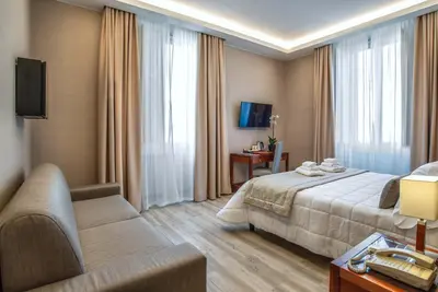 a hotel room with a bed and a couch at Hotel Genova in Rome