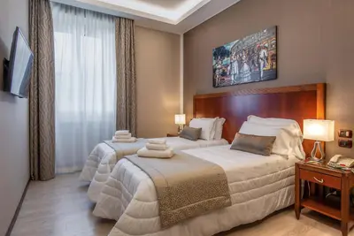 a hotel room with two beds with towels on them at Hotel Genova in Rome