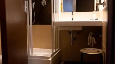 a bathroom with a shower and a sink and a stool at Hotel Re Di Roma in Rome