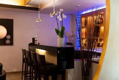 a bar with black chairs and a vase of flowers at Hotel Re Di Roma in Rome