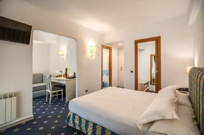 a hotel room with a bed and a desk at Hotel Napoleon in Rome