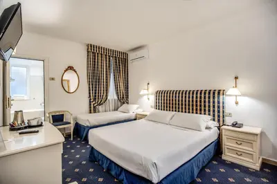 a hotel room with two beds and a mirror at Hotel Napoleon in Rome