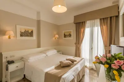 a bedroom with a bed and a vase of flowers at Hotel Modigliani in Rome