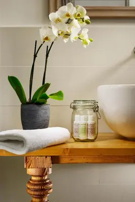 a wooden shelf with a jar and a bowl and flowers at San Pietro Boutique Rooms in Rome