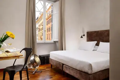 a hotel room with a bed and a desk and a window at San Pietro Boutique Rooms in Rome