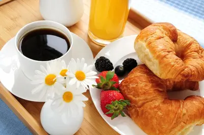 a plate of food with a croissant and a cup of coffee at San Pietro Boutique Rooms in Rome