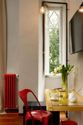 a table with two red chairs and a window at San Pietro Boutique Rooms in Rome