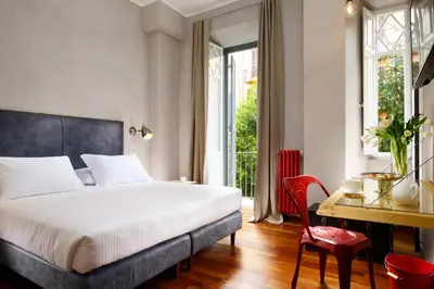 a bedroom with a bed and a desk with a chair at San Pietro Boutique Rooms in Rome