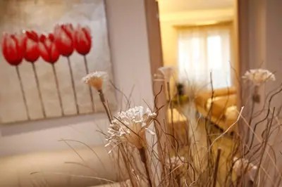 a vase filled with red flowers in a room at Casa Eli Roma B&B in Rome