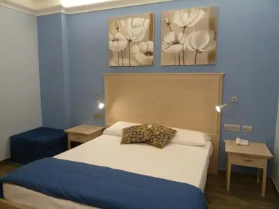 a bedroom with a bed with three pictures on the wall at Casa Eli Roma B&B in Rome