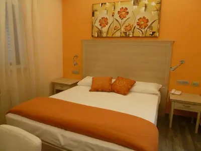 a bedroom with a bed with orange walls at Casa Eli Roma B&B in Rome