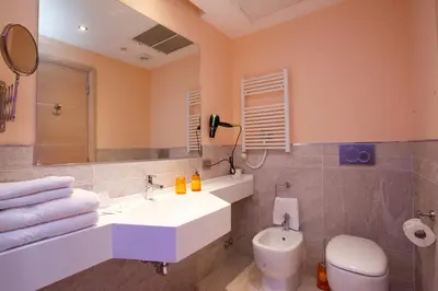 a bathroom with a sink and a toilet and a mirror at Casa Eli Roma B&B in Rome