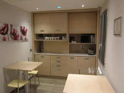 a kitchen with wooden cabinets and a table and chairs at Casa Eli Roma B&B in Rome