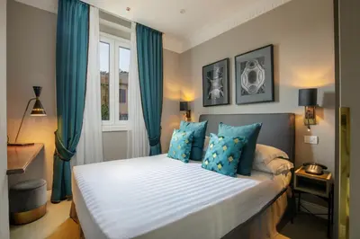 a bedroom with a large bed with blue curtains at Condotti Boutique Hotel in Rome