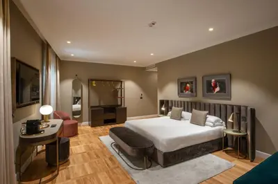 a bedroom with a bed and a table and a chair at Condotti Boutique Hotel in Rome