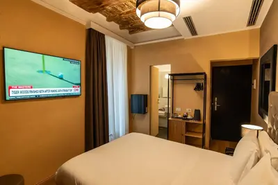 a bedroom with a bed and a tv on a wall at Hotel Elite in Rome