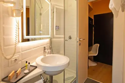 a white bathroom with a sink and a mirror at Hotel Elite in Rome