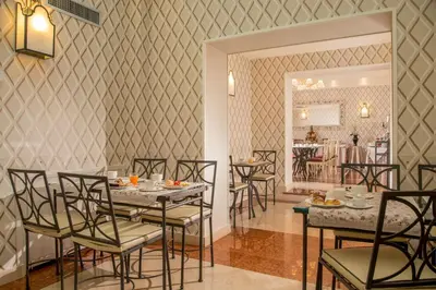 a dining room with a table and chairs and a kitchen at Hotel Villa Glori in Rome