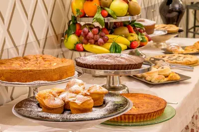 a table topped with cakes and pastries and fruit at Hotel Villa Glori in Rome