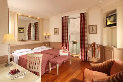 a hotel room with a bed and a table and chairs at Hotel Villa Glori in Rome